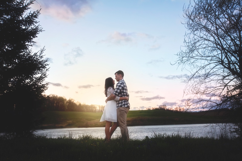 Couples Photographer, couple standing next to lake looking at each other