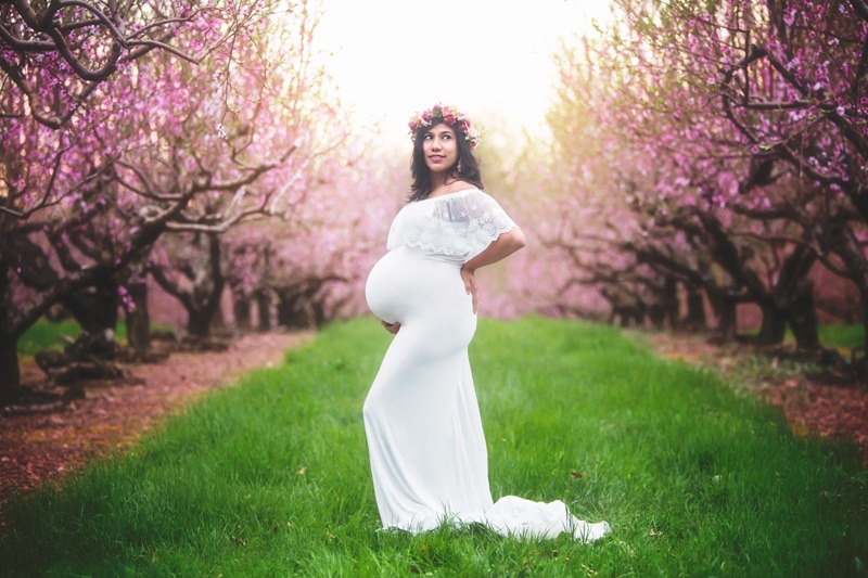 Maternity Photographer, pregnant woman in white dress next to flowering trees