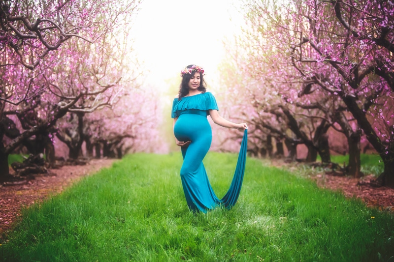Maternity Photographer, woman in blue dress holding up her dress