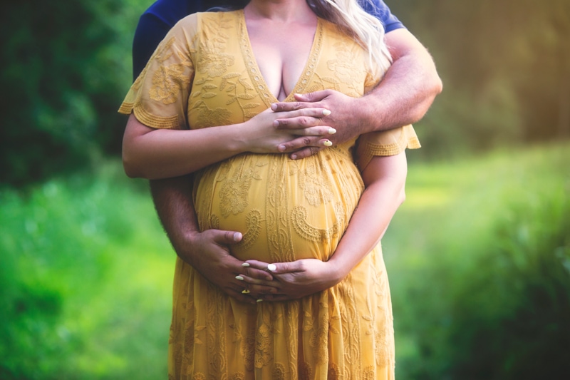 Maternity Photographer, man with his arms wrapped around woman
