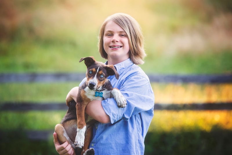 Family Photographer, teen boy holding up a dog
