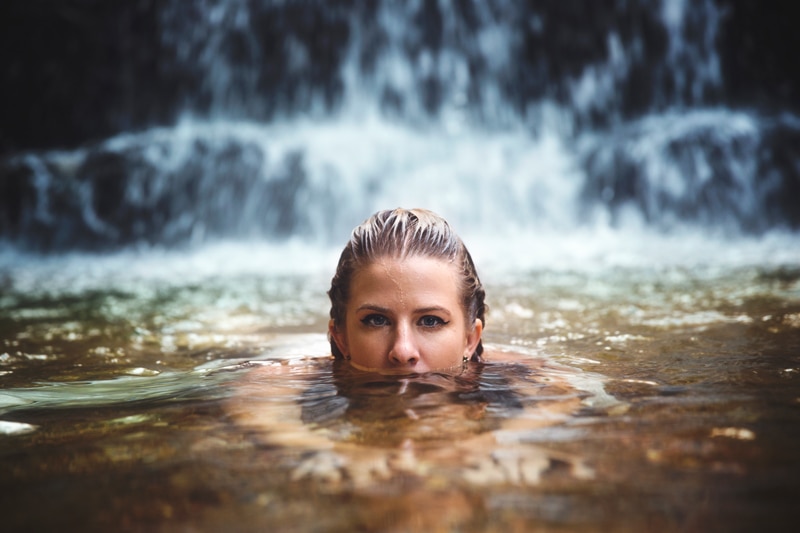 Portrait Photographer, woman swimming with her eyes sitting just above the water