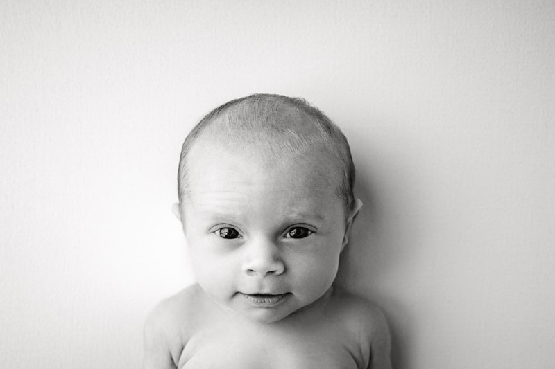 Newborn Photography, black and white image of baby looking at the camera
